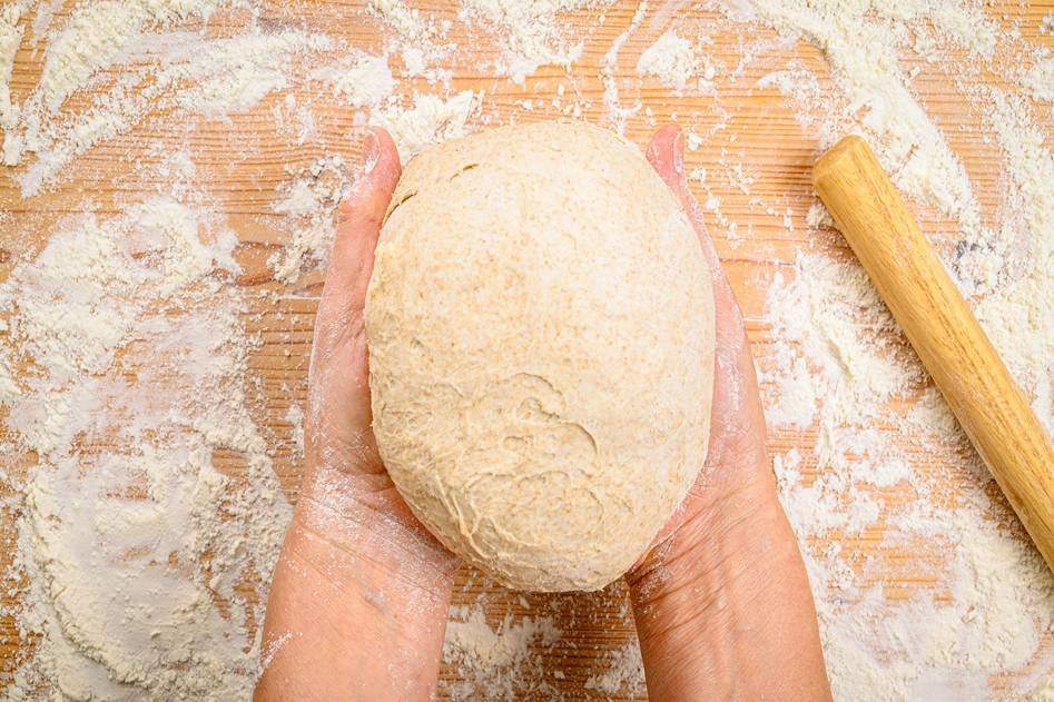 Bread machine with fresh loaf on wooden counter