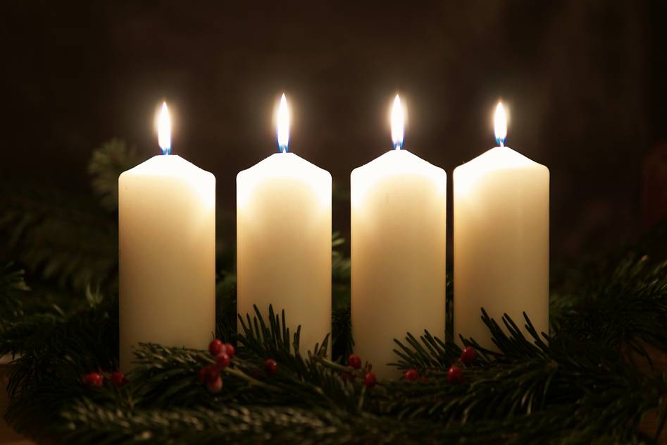 Elegant brass candle holders on a wooden mantel with soft glowing candles