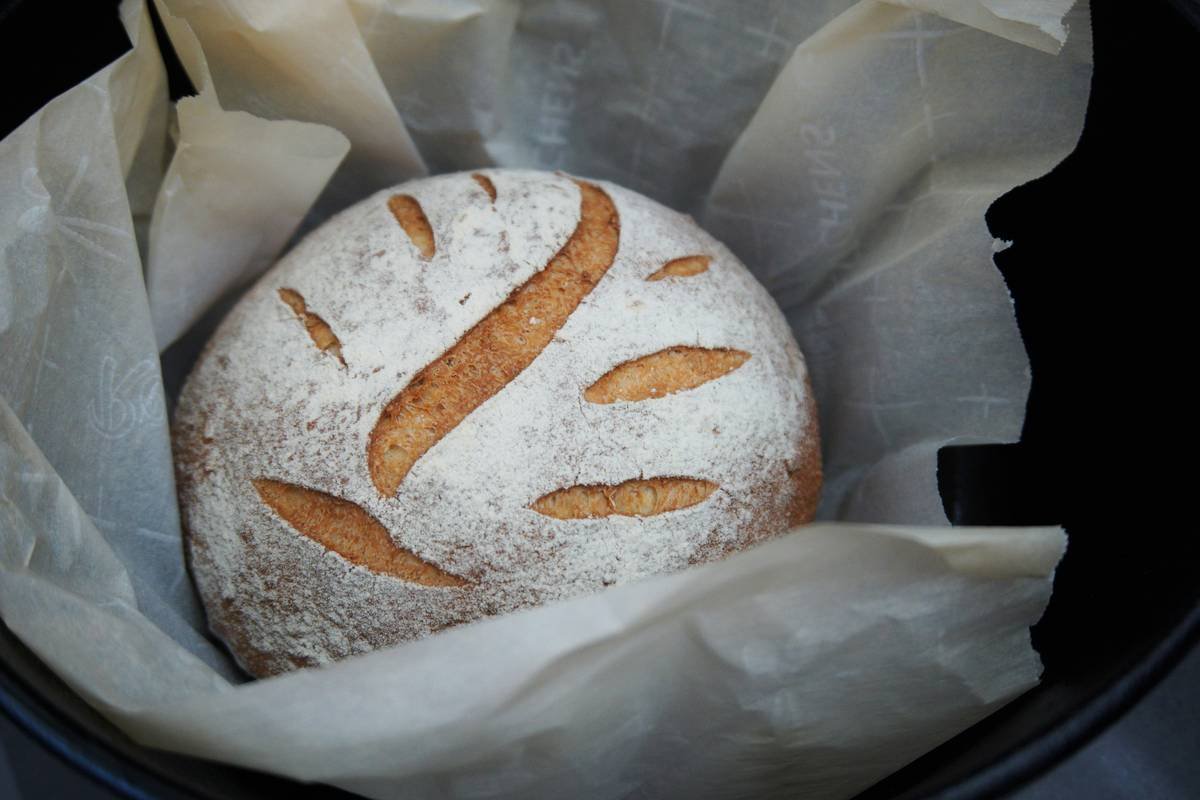 Golden sourdough loaf mid-bake while cooking bread uncovered on a preheated baking steel