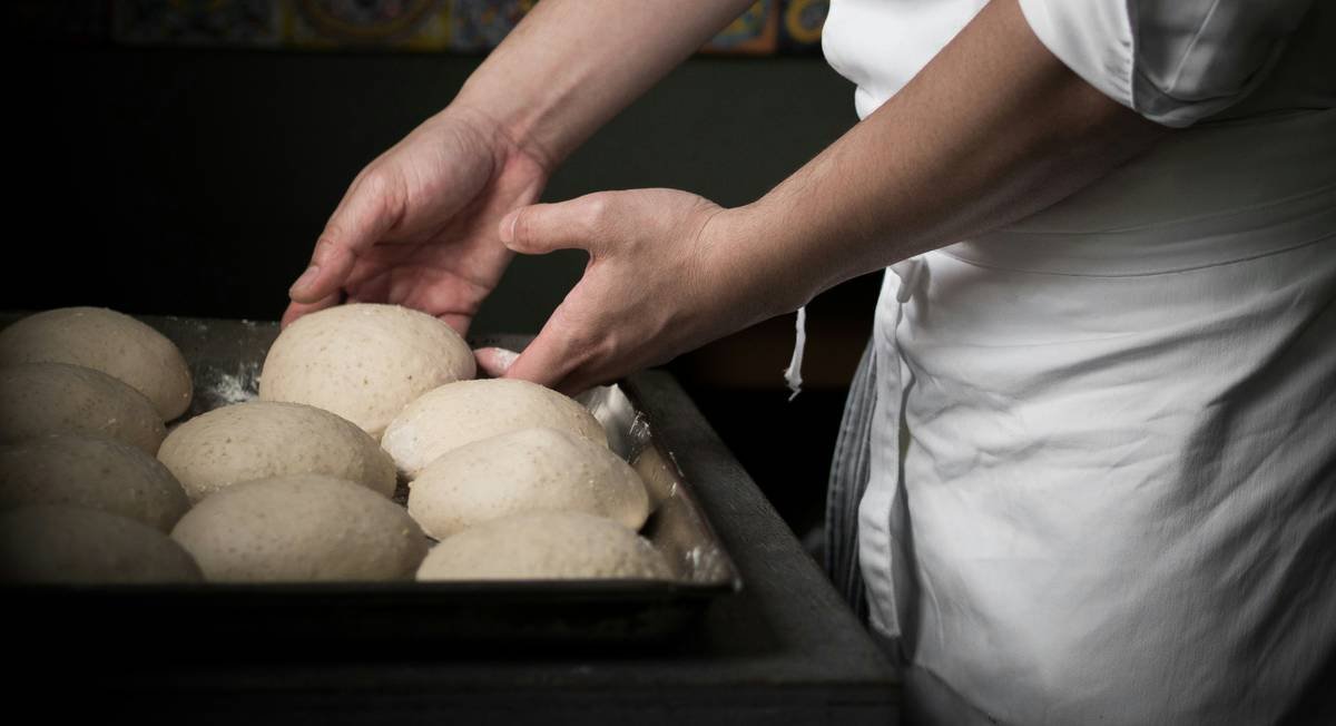 Close-up of making bread using dough hook in a stand mixer with well-developed elastic dough