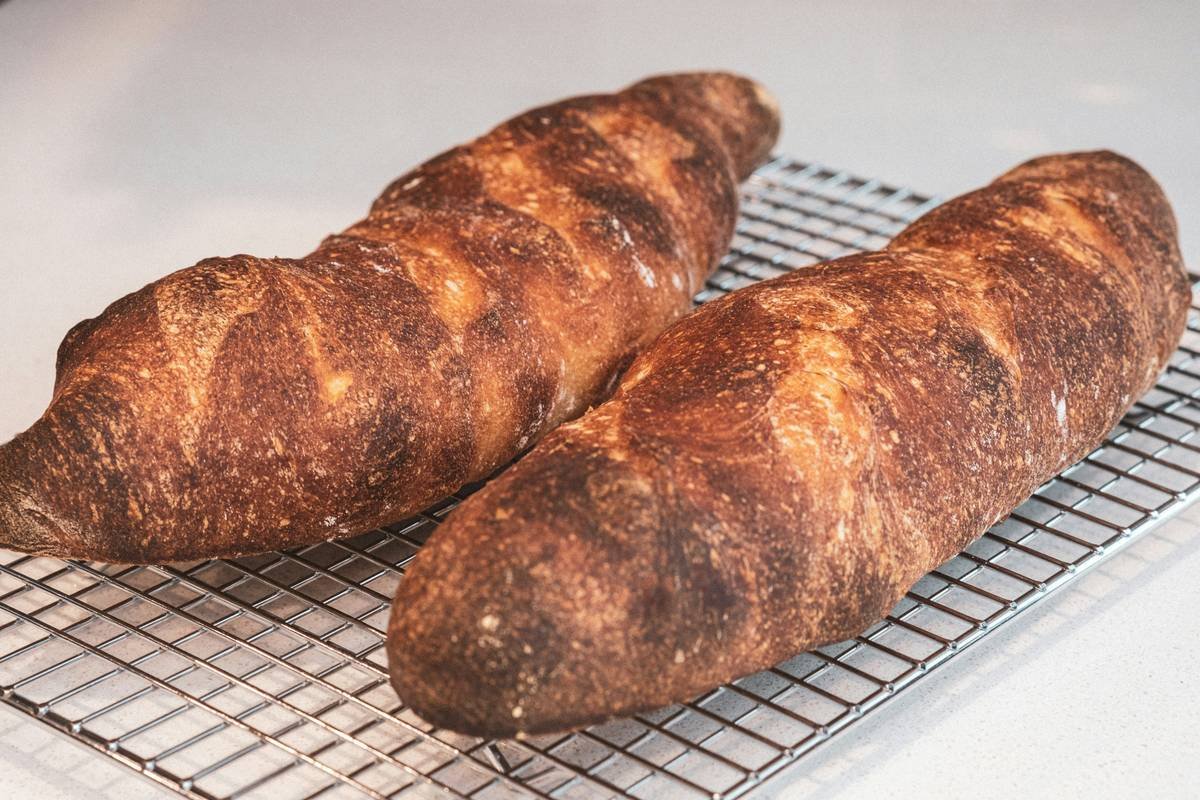 Side-by-side chart comparing loaf results using aluminum vs. dark non-stick vs. stainless steel bread tins, showing crust color, rise height, and crumb structure